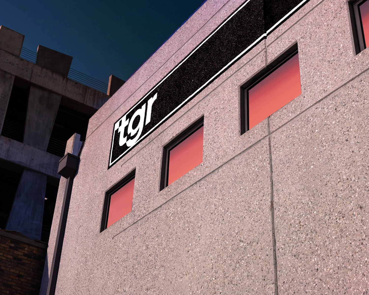 TGR’s Los Angeles building at sunset, with the TGR sign and warm light reflected in the windows